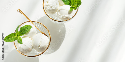 Vanilla Ice Cream in Elegant Glass Bowls on White Table with Sunlight