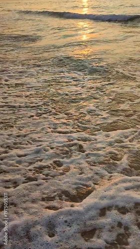 Sunset or dawn in sea. Sundown or sunrise on the ocean. A sunny path on the sea waves. Sun, sky, clouds, sea, sea waves, sandy shore, beach. Morning and evening on coast. Vertical