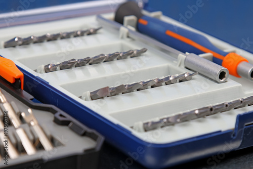 A set of metal bits for installation work in a plastic case.