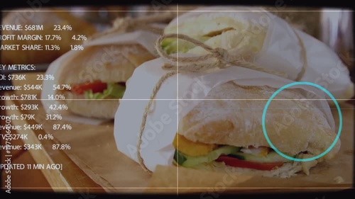 HUD animating on cue over sandwiches still cyan reticle settling on roll showing margins for bakery