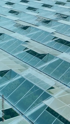 Vertical video: Camera panning along glass roof panels and vents, overlaying bar chart for farming