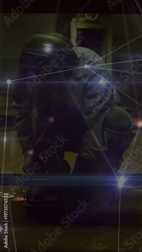 Vertical video: Welder kneeling bringing tool to rail, grinding sparks, cutting, flares on helmet