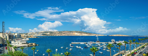 Panorama of shoreline and embankment. Boats moored in harbour. Bugibba. Saint Paul's Bay. Malta