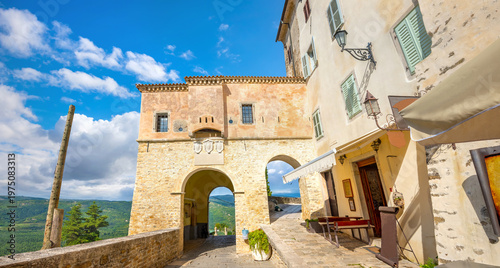View of old house with restaurant and ancient entrance gate at little town Motovun. Istria, Croatia