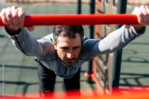 Cuadro en lienzo Man exercising on outdoor fitness equipment
