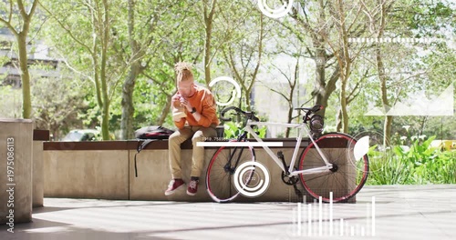 seated man tapping phone, activating AR technology graphics over bicycle, reviewing ride metrics