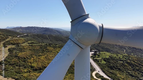 Close up on wind turbine turbine with green mountains and the strait of Gibraltar in the background