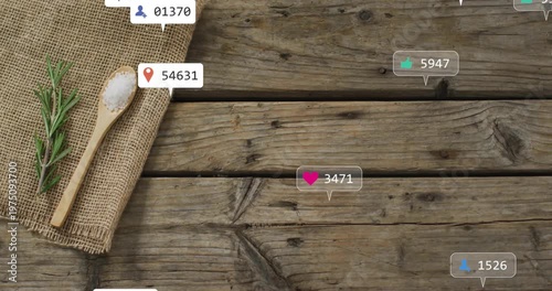 Rustic tabletop showing wooden spoon holding coarse salt and rosemary sprig with social media icons