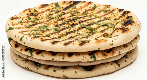 Stack of grilled naan bread with herbs on white background