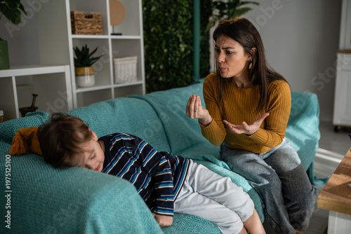 Foto Mother scolding sulking child on sofa at home
