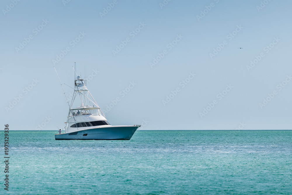 Obraz premium Offshore saltwater sport fishing boat on a sunny summer day. Fisherman on large powerboat on the Gulf of America, Florida.