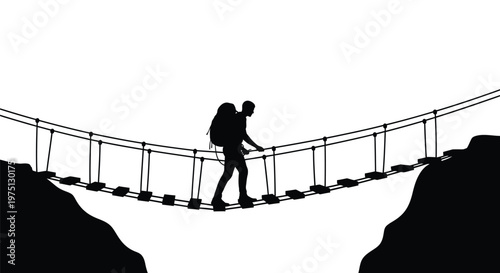 Hiker crossing a rope suspension bridge against a mountainous backdrop silhouette