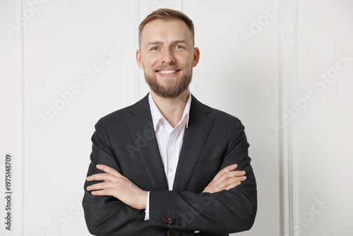 Photography Portrait of handsome man in suit near white wall indoors