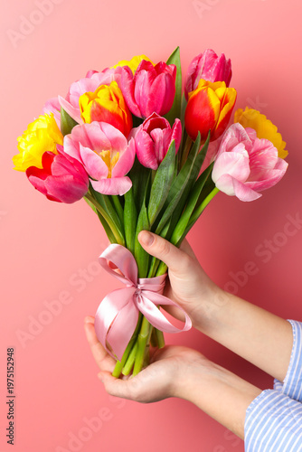 Woman with bouquet of aromatic bright tulips on pink background, closeup. Beautiful greeting card