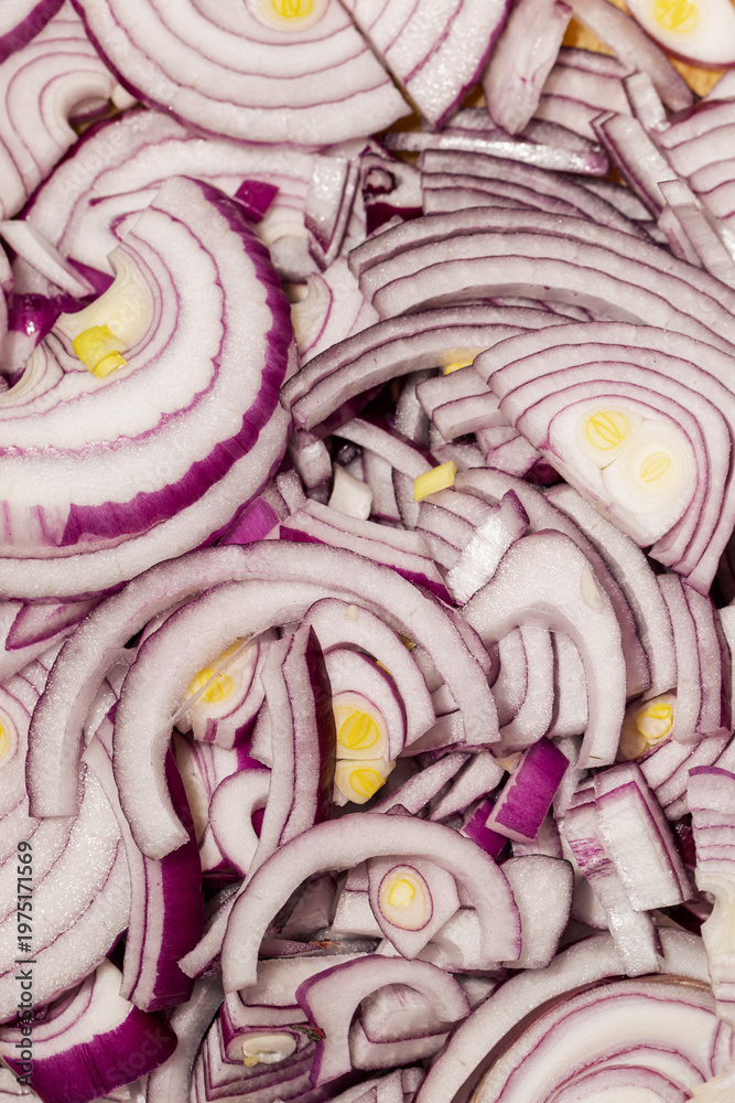Obraz premium Close up of sliced red onion with layered texture background Fresh chopped red onion rings with detailed vegetable texture Raw purple onion slices as food background and cooking ingredient