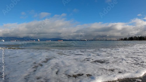 English Bay Waves on Shore Vancouver Skyline 4K UHD. Ocean wave breaking on Spanish Banks beach. The Vancouver skyline in the background. 4K UHD.
