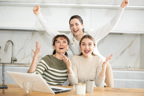 Canvas Print Women are reading email on laptop screen, cheering over good news, shouting triu