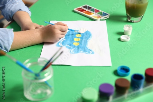 Φωτογραφία Little girl painting picture with paints and brush on green background, closeup