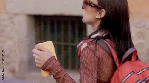 Happy young woman dancing while walking down a city street