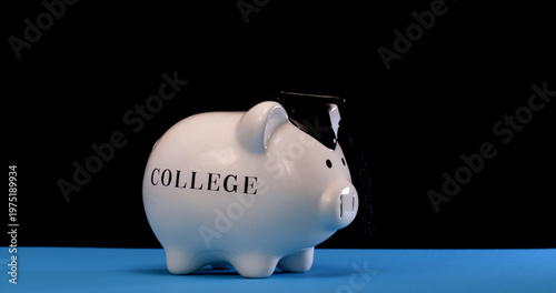 Piggy bank with a graduation cap on a blue surface represents college savings for students and education expenses in a creative way
