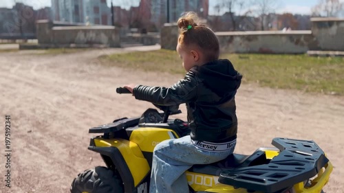 Child enjoying electric ride-on ATV outdoors. Popular kids toy for active play, adventure and fun. Perfect gift for children and modern outdoor entertainment