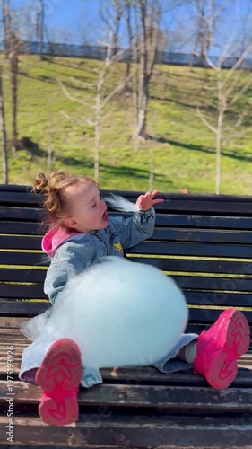 Smiling child enjoying cotton candy in a sunny park. Pure childhood joy, sweet moments, carefree emotions and happy family lifestyle outdoors.
