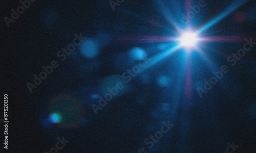 Abstract light flare glowing in dark background with blue lens flare and bright starburst illumination, soft bokeh circles and cinematic glow effect,