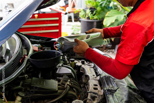 Photos Mechanic pouring engine oil into car engine in garage routine vehicle maintenanc
