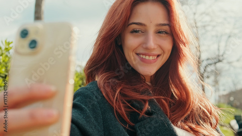 Selfie Portrait Of Happy Red-Haired Woman Outdoors