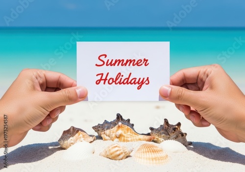 Hands holding summer holidays sign at the beach