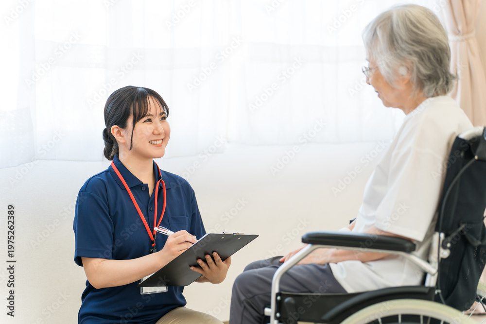 Obraz premium A female caregiver interviews a senior woman in a wheelchair.