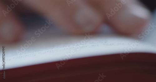 Extreme Close-up of a man's finger reading and scrolling through a prayer book