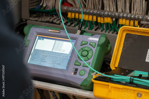 Two technicians measure the signal level in the fiber optic cable. Serving a central router in a server room. Two people work in a modern data center.