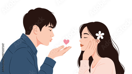 Romantic young man blows a pink heart from his hand towards a smiling woman with a flower in her hair against a plain background.