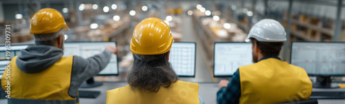 Industrial Oversight: Focused on computer screens, several workers monitor the production line, ensuring efficient operation within a modern factory environment.