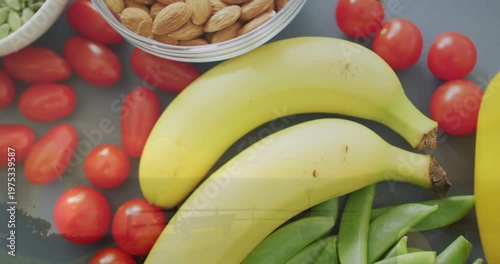 Top-down camera shifting, showing food, bananas moving, peas appearing, nut bowl, pepper entering