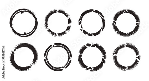 Set of eight black grunge circle stamp frames with distressed textures and irregular borders isolated on white background.
