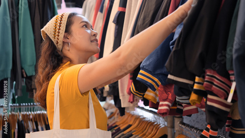 Принти на полотні Young teen tourist Gen Z asia female choose look at zero waste eco go green buy second hand sale store flea market thrift old used vintage fabric style