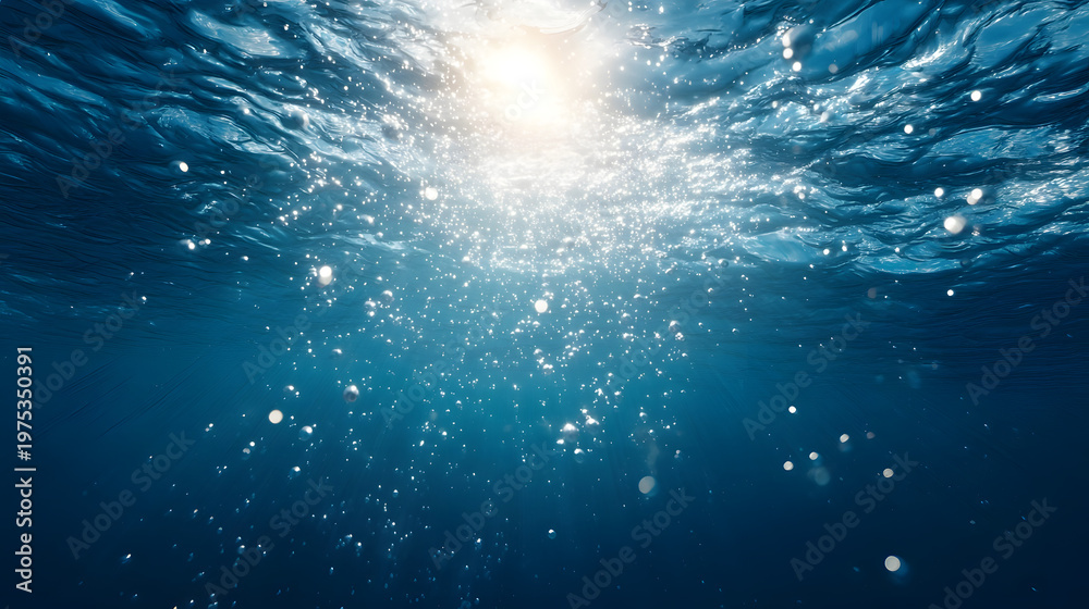 Fototapeta premium Abstract underwater background with blue water surface and many rising oxygen bubbles in bright sunlight.