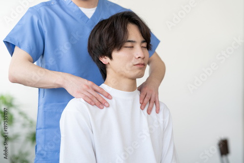 整骨院で整体をする若い男性