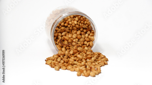 Roasted peanuts isolated on a white background, top view. Pile of shelled peanuts with a few scattered nuts on white background. Dry roasted peanuts isolated on white.