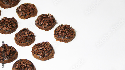 Delicious chocolate cake topped with chocolate chunks, on a white background. Freshly baked chocolate cake with a rich cocoa texture and chocolate shavings.