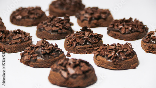 Delicious chocolate cake topped with chocolate chunks, on a white background. Freshly baked chocolate cake with a rich cocoa texture and chocolate shavings.