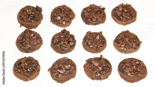 Delicious chocolate cake topped with chocolate chunks, on a white background. Freshly baked chocolate cake with a rich cocoa texture and chocolate shavings.