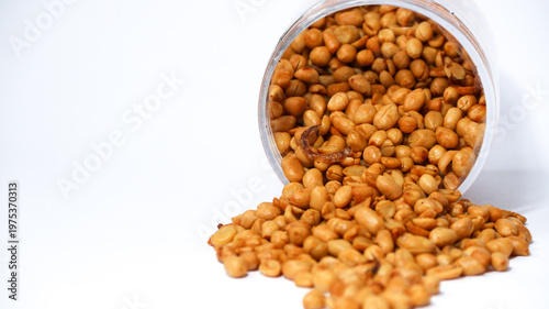 Roasted peanuts isolated on a white background, top view. Pile of shelled peanuts with a few scattered nuts on white background. Dry roasted peanuts isolated on white.