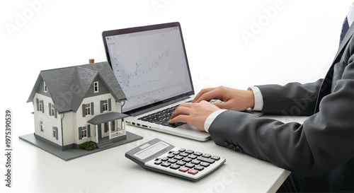 Businessman Calculating Mortgage on Laptop with House Model