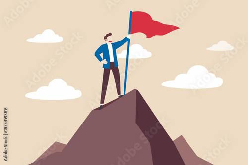 A man triumphantly plants a red flag atop a rocky mountain peak