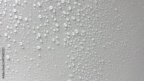 Large droplets of water drip on a light background and flow down in streams. The concept of rain, moisture, drops, moisture. High quality 4k footage