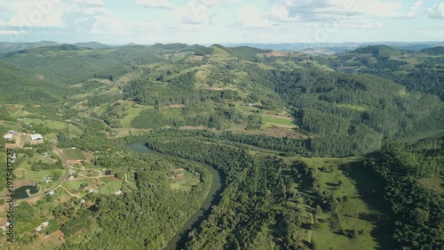 A winding river among crop fields and forests. Drone footage. 