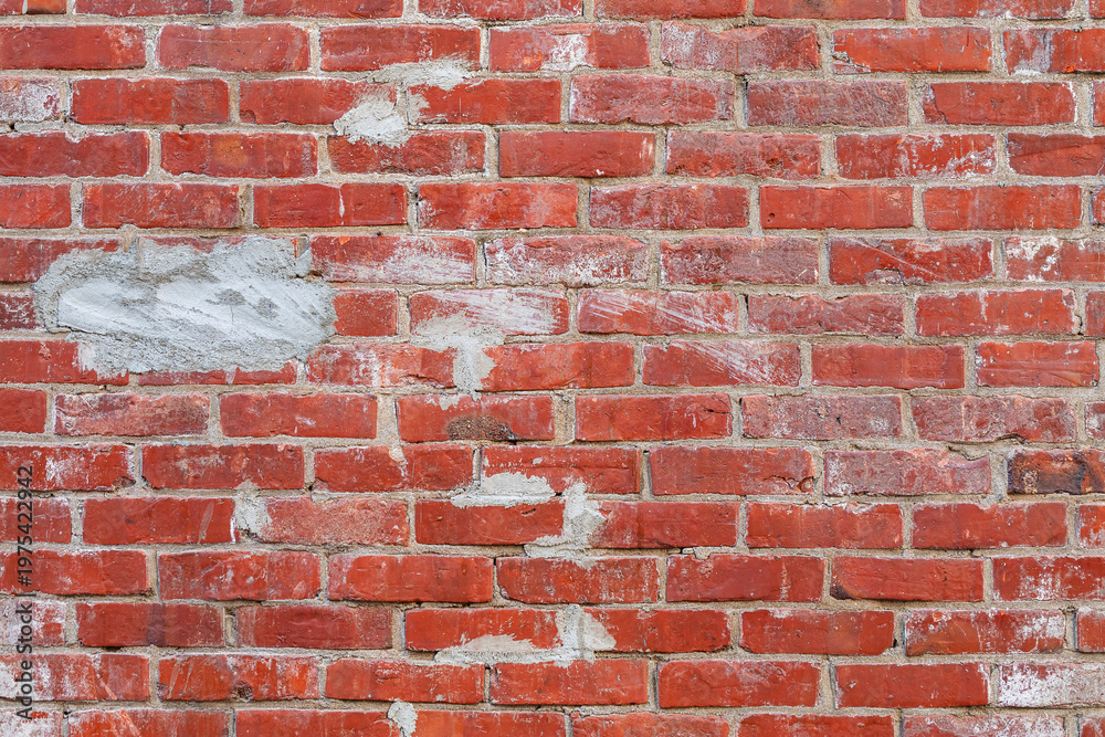Fototapeta premium old red brick wall with grey cement patches texture background